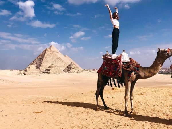 great-shot-of-a-female-tourist-standing-on-a-camel